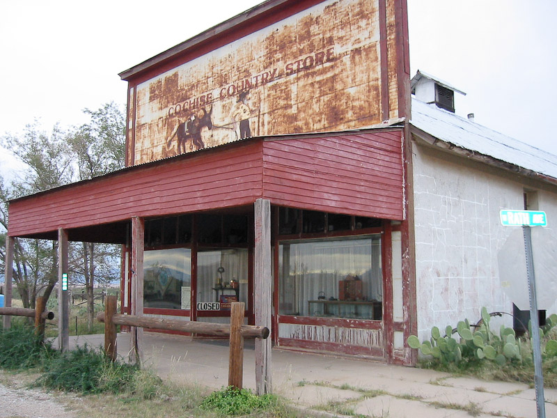 Note the stands for securing horses in front of the store.