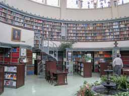 The spiral stairs lead to the upper deck of the library. Note the plants, subject to a century of debate over their worth in a library. Photo © Lawrence I. Charters