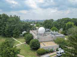 Main building holding the atomic clock, which sets the critical time standard for use in US navigation, and is also used by millions of computers for coordinating time. The dome is for satellite communications. Backup clocks are located in other buildings on campus. Photo © Lawrence I. Charters